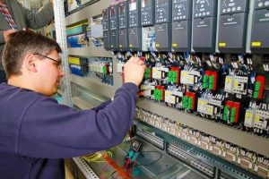 Man at Work in Control Cabinet for Corrugator Automation